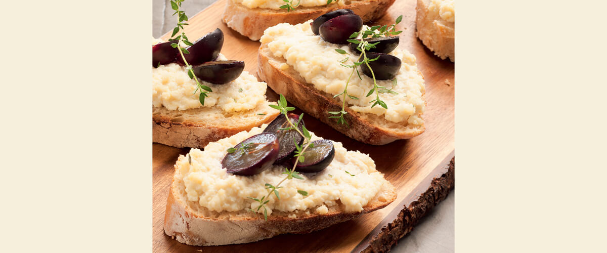 Bruschetta com queijos, uvas assadas e mel